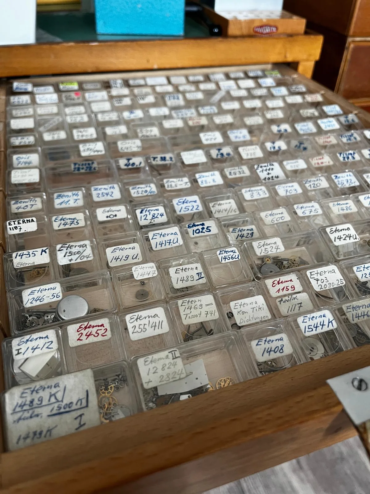 Sortierte Ersatzteilschubladen mit Eterna- und Zenith-Kalibern im Uhrmacher-Atelier