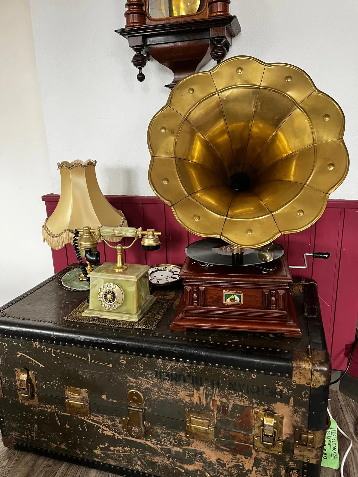 Vintage-Ecke im Atelier mit Grammophon, antikem Telefon und Wanduhr auf historischem Reisekoffer